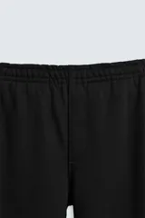Pantalón jogger gris de corte recto, confeccionado en tejido de algodón compacto con interior en rizo. Tiene cintura elástica ajustable con cordón interior, bolsillos frontales y bolsillo de doble vivo en la espalda.
