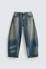 Pantalón de jean celeste con efecto lavado, corte amplio tipo balloon fit, tiro medio, cinco bolsillos y cierre frontal con cremallera y botón.
