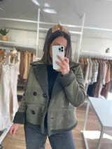 Chaqueta marrón con forro tipo corderito, doble botonadura y cuello con solapas.
