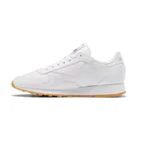 Championes Reebok Classic Leather blancos con detalles en rojo y suela de goma color caramelo.