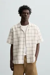 Camisa de manga corta con cuello bowling y corte relaxed fit, confeccionada en tejido con mezcla de algodón y estampado a cuadros.