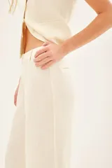 Pantalón de lino color crema, de corte sastrero y pierna ancha, con cintura alta y bolsillos laterales.