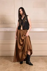 Chaleco blanco con bordados de hilo y canutillos, escote en V y cierre frontal con botones.