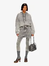 Bolso tipo cubo para mujer con forma fruncida y acabado en cuero brillante. Presenta el logotipo 'D' metálico en el centro y cordones ajustables con detalles metálicos. Incluye múltiples bolsillos internos.