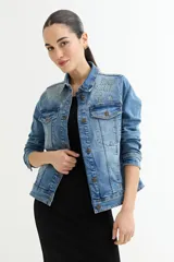 Chaqueta de jean celeste con apliques de strass en cuello y hombros, corte clásico, mangas largas y bolsillos frontales.