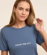 Conjunto de pijama short doll, compuesto por una remera azul con estampado de la frase "Chase The Sun" y un short a rayas verticales blancas y azules con cintura elástica.