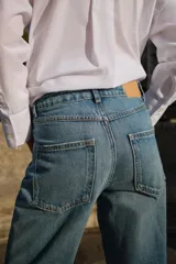 Pantalón de jean gris de corte recto, tiro alto y largo hasta el tobillo.