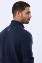 Campera tejida de lana color azul marino, con cuello alto, cierre metálico frontal y bolsillos laterales. Presenta detalles en cuero y logo bordado.