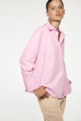 Camisa amarilla de popelina de algodón, con cuello solapa, escote en pico, manga larga con puños y cierre frontal con botones.