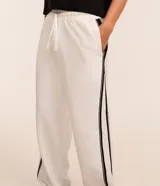 Pantalón wide leg de helanca color blanco, con cintura elástica ajustable con cordón, bolsillos laterales, raya lateral negra y bajo ajustable.