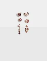 Set de tres pares de aros con distintos pasantes con strass y corazones bañados en oro rosa.