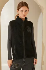 Chaleco negro de boucle con cuello alto y cierre frontal con cremallera.