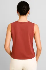 Musculosa color ladrillo con estampa dorada de una guitarra alada y la leyenda "Rock & Roll 1974".