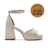 Sandalias de vestir de cuero color crudo, con plataforma y taco cuadrado alto. Tira fina con hebilla alrededor del tobillo.
