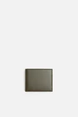 Billetera tipo cartera de corte liso color verde militar. Cuenta con un compartimento para billetes, tres compartimentos para tarjetas y un monedero con cierre mediante clip.