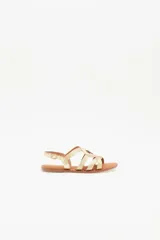 Sandalias bajas doradas con tiras finas cruzadas y hebilla en el tobillo.
