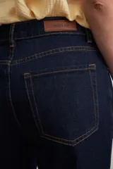 Pantalón de jean azul oscuro, de corte acampanado y tiro alto.