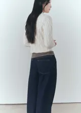 Sweater color crema de punto trenzado con cuello Perkins y mangas largas con puños elásticos.