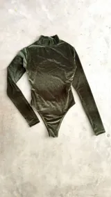 Body de terciopelo marrón con estampado de piel de serpiente, cuello alto, mangas largas con orificio para el pulgar y espalda descubierta.