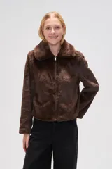 Chaqueta corta negra de piel sintética con cuello clásico, cierre frontal con cremallera y mangas largas.