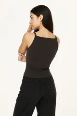 Musculosa blanca ajustada al cuerpo, de bretel fino y escote cuadrado.