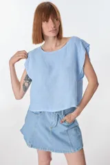Blusa celeste de lino con mangas cortas con volados.