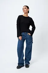 Pantalón de jean gris oscuro, tiro bajo, corte baggy y doble bolsillo.