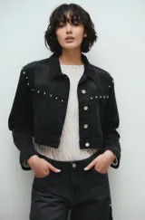 Campera de jean negra, corte crop, con cuello clásico, cierre frontal con botones metálicos y tachas plateadas en hombros y solapas.