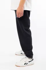 Pantalón de jogging negro de corte holgado con logo 'VERNAL' bordado en azul en el muslo izquierdo.