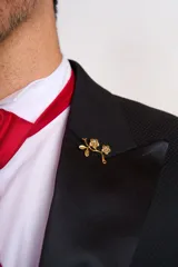 Traje de vestir azul con solapa de satén, compuesto por saco con cierre de un botón, pantalón de corte entallado y moño de satén azul.