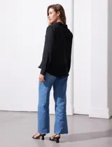 Camisa blanca de manga larga con cuello con solapa y abertura central con botones. Delantera con bolsillos aplicados.