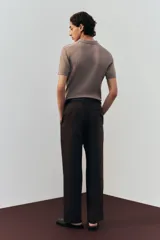 Pantalón marrón de corte amplio, confeccionado en mezcla de lino y algodón. Cuenta con cierre frontal con botón y corchete ocultos, bolsillos laterales ribeteados y bolsillos traseros insertados con botón.