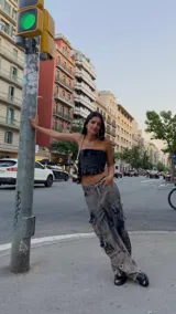 Pantalón cargo oversize de jean con efecto lavado, múltiples bolsillos funcionales y detalles metálicos en bronce.