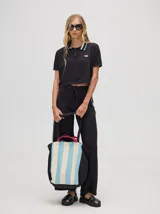 Pantalón de algodón negro, corte holgado y pierna ancha con pretina elástica. Presenta rayas bicolor al costado en blanco y celeste. Calce de tiro alto.