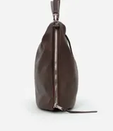 Bolso hobo grande desestructurado de PU color negro, con correa de mano, correa larga desmontable, cierre lateral ajustable con tiradores y cierre superior.