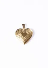 Dije relicario dorado con forma de corazón y diseño floral.