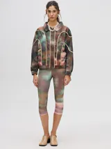 Campera rompevientos estilo biker con capucha desmontable, color celeste con estampado de nubes blancas y detalles en blanco.