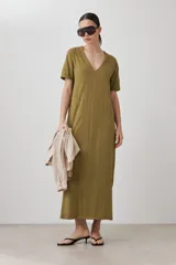 Vestido largo color verde oliva, con cuello en V, mangas cortas y costuras verticales.
