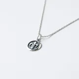 Conjunto de collar y dije de plata 925 con diseño de flor de lis. El collar tiene una cadena de 50cm de largo y 1.2mm de ancho. El dije tiene un diámetro de 17mm.