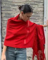 Pashmina roja tejida en lana con detalles en cinta tejida y flecos.