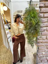 Pantalón sastrero color beige de lino, corte recto y tiro alto, con bordado de caballo en el bolsillo trasero.