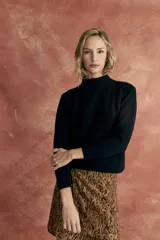 Sweater negro de tejido de punto con cuello alto y diseño de trenzas en el frente.