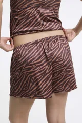Conjunto de pijama de satén con estampado de cebra en tonos marrones. Incluye un top de tirantes con encaje en el escote y un short con cintura elástica.