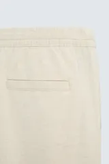 Pantalón azul marino de corte recto, con cintura elástica ajustable con cordón, bolsillos laterales y traseros.