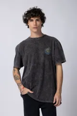Remera de hombre color gris oscuro con efecto gastado (snow wash), corte semi-oversize y un pequeño estampado circular en el pecho que simula una obra de arte.