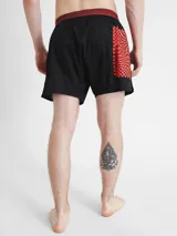 Short de baño negro con cintura elástica roja con logo Calvin Klein y estampado de tablero de ajedrez con logo CK en la pierna.