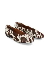 Ballerina plana de mujer con estampado de vaca (marrón y blanco). Presenta punta cuadrada y un pequeño tacón bajo.