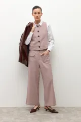 Pantalón de tiro alto, corte ancho y largo, con estampado de pata de gallo pequeño en tonos beige y rosado/marrón. Presenta bolsillos delanteros con solapa.