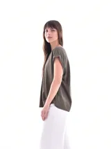 Blusa blanca de corte holgado, con cuello en V y mangas cortas.