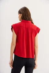 Camisa azul petróleo de viscosa y modal, manga corta, cuello camisero y frunces en los hombros.